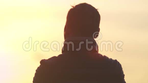 摄影背景活跃的男性游客穿着夹克欣赏惊人的黄色日落视频的预览图