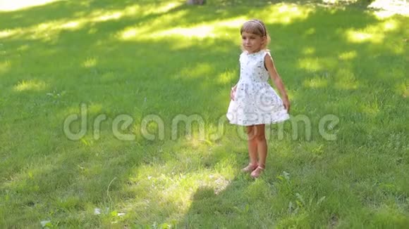 一个穿着夏装的可爱的小女孩在公园里转来转去视频的预览图