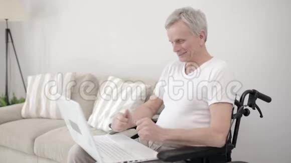 一位坐在当地医院轮椅上的灰发男子正在他的房间里用Skype和他的家人交谈视频的预览图