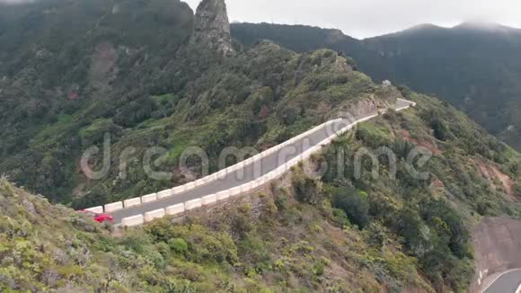 航空景观一辆孤独的汽车穿过一条狭窄而危险的道路高高的青山高蛇纹石视频的预览图