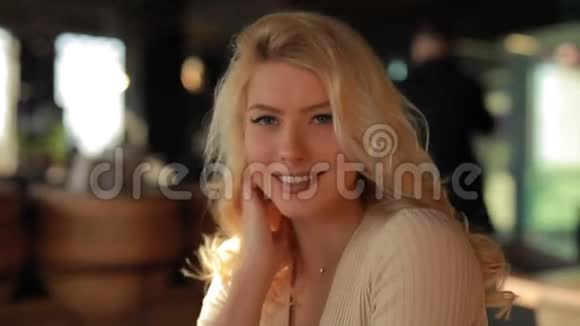 性感迷人的女人抚摸着坐在咖啡馆里的头发看着我调情视频的预览图