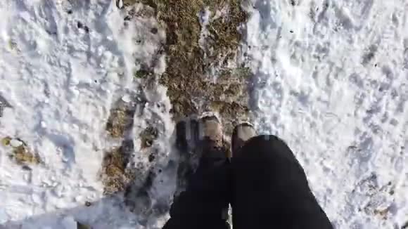 希克尔的观点一个人走在草地和雪地之间的山路上的POV特写视频的预览图