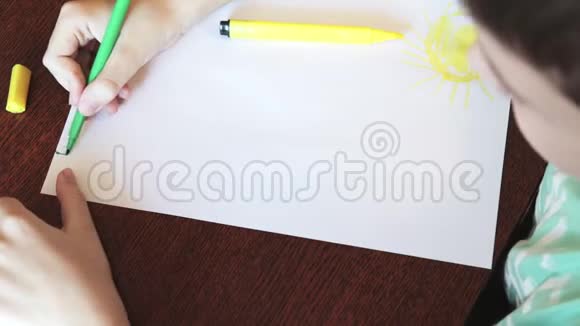 一个男孩坐在书桌前用白纸上的彩色记号笔画素描视频的预览图