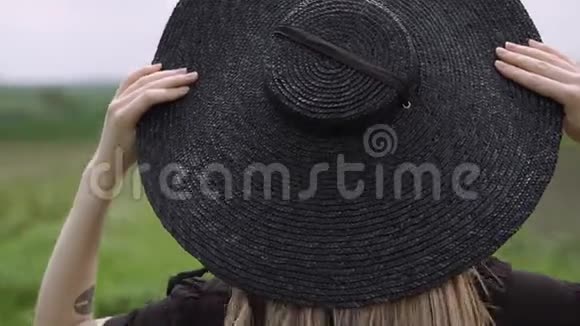 金发手托着大黑帽子手托着她的头视频的预览图