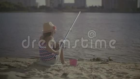 漂亮的小女孩在用旋转棒钓鱼视频的预览图