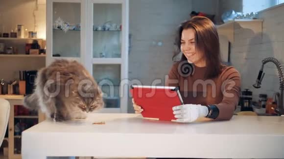一位年轻女子手中有一只仿生手身边有一只猫视频的预览图
