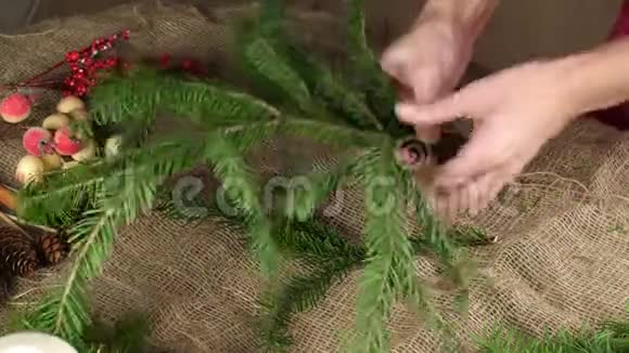 一个花店女手撕下一小片云杉创造一个圣诞作文准备装修视频的预览图