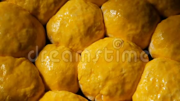 一个黄色的鸡蛋从烤盘上的面团中润滑球使其呈现出玫瑰色视频的预览图