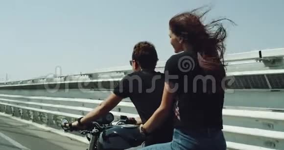 骑摩托车的特写情侣骑着摩托车他们夏天很开心在高速公路上的女士抱着可爱的男人视频的预览图