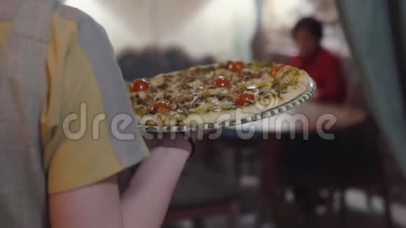 服务员端着美味可口的圆形奶酪披萨给顾客视频的预览图