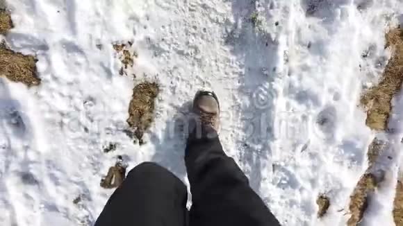 希克尔的观点一个人走在草地和雪地之间的山路上的POV特写视频的预览图