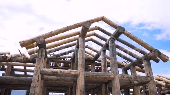 在蓝色多云的天空背景下建造一座由原木制成的木屋剪辑环境的基本观点视频的预览图