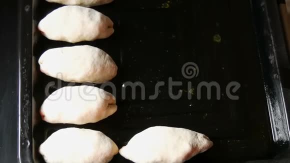 女人手面包师把面团以细长圆球的形式连续放在黑色烤片上近距离观看自制面团视频的预览图