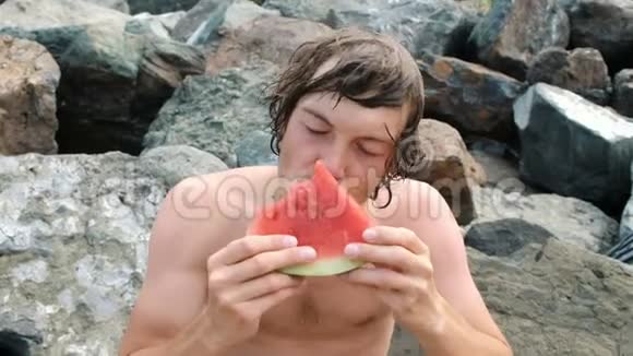 一位英俊的年轻人手里拿着一片西瓜吃东西的画像视频的预览图