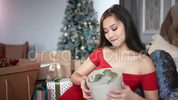 期待优雅的年轻亚洲女人打开圣诞礼盒微笑视频的预览图