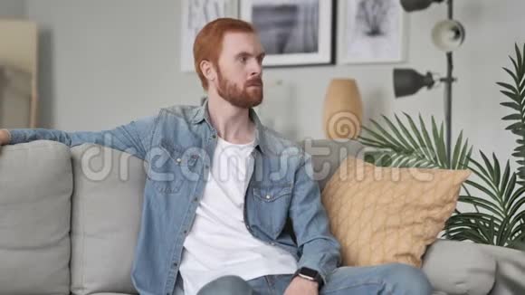 创意空间中坐沙发的严肃男人视频的预览图