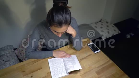 年轻的黑发女孩读书准备考试视频的预览图