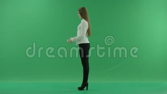 快乐的商务女性正站在绿色屏幕的左边用电话聊天视频的预览图