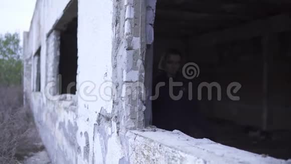 年轻的金发女孩在被遗弃的废墟残窗洞世界末日后的斯托克视频的预览图