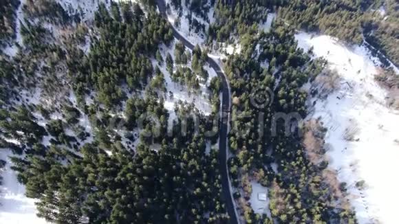 穿越森林的蜿蜒道路积雪多4k内俯视视频的预览图