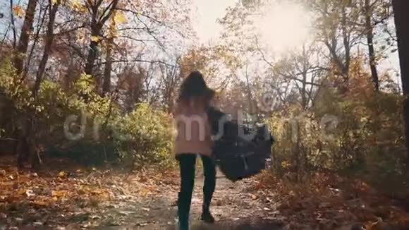 害怕的年轻女子白天在秋林的小路上奔跑后景视频的预览图