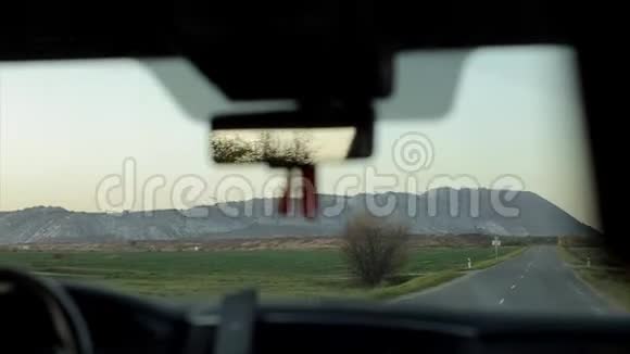 日出时在乡间柏油路上开车从车内看风景视频的预览图