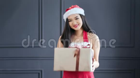 圣诞节期间可爱的女圣诞老人在演播室中镜头下赠送了大礼盒视频的预览图