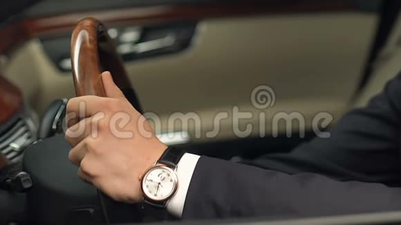 穿西装的人坐在驾驶位置拿着方向盘买新车视频的预览图