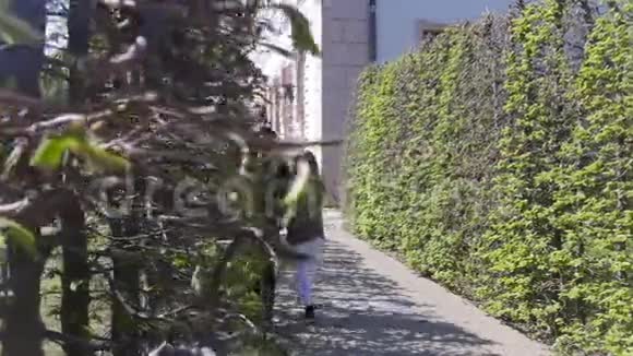 一对年轻夫妇在公园的装饰植物间散步视频的预览图