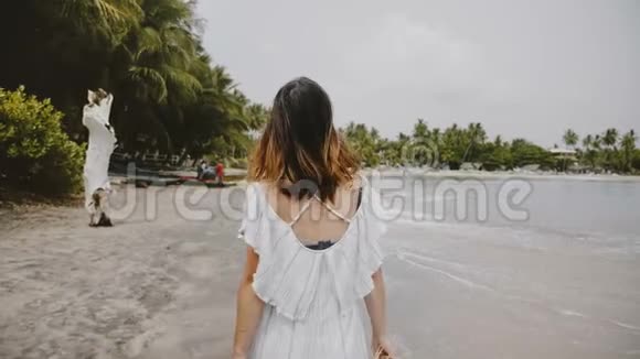 慢动作特写镜头跟随美丽的快乐旅游妇女走在惊人的热带海滩与草帽视频的预览图