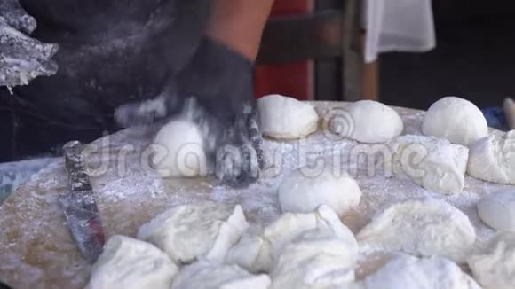 厨师戴着黑色手套把生面团切成碎片做披萨饼面包视频的预览图