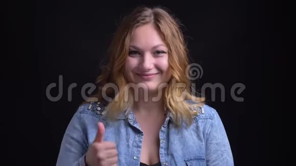 成年白种人女性的特写镜头在看镜头和微笑时自信地伸出大拇指视频的预览图