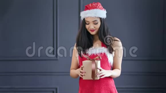 亚洲圣诞老人小女孩手持圣诞小礼品盒中镜头肖像视频的预览图