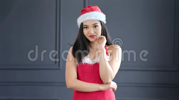 戴着圣诞老人帽子和西装的亚洲年轻漂亮女人的肖像视频的预览图