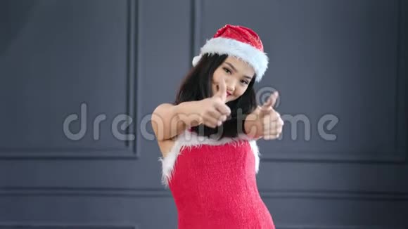 微笑的年轻圣诞老人女士竖起大拇指做一个冷静的手势视频的预览图