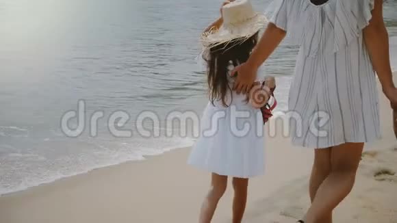 镜头跟随幸福美丽的年轻母亲和两个孩子一起在海洋海滩上享受异国情调的假期视频的预览图