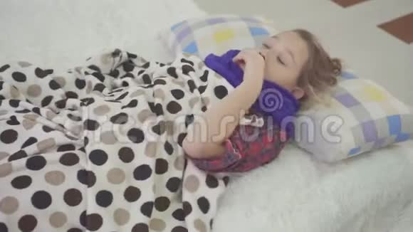 3睡在床上的小女孩在家感冒咳嗽剧烈喉咙痛视频的预览图