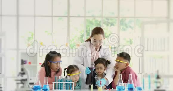 老师在实验室里把化学物质倒进烧杯里视频的预览图