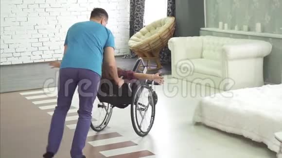 在家坐轮椅的快乐残疾孩子和他的父亲视频的预览图