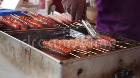 小贩在当地市场上烤香肠街头美食4k视频的预览图