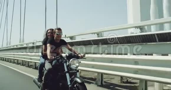 拍摄镜头前的视频年轻漂亮的一对夫妇在阳光明媚的夏日骑摩托车视频的预览图