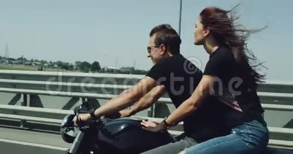 在高速公路上这对夫妇在夏天骑着一辆大摩托车带着一对有风的漂亮夫妇视频的预览图