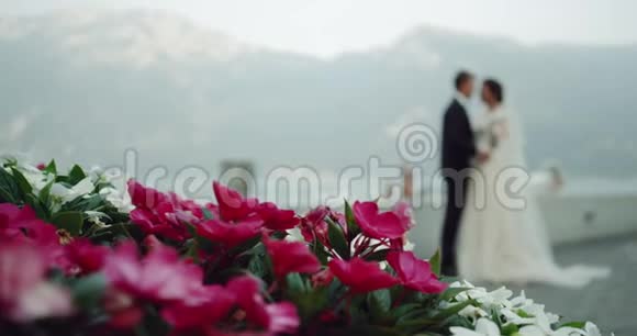 在意大利山和湖中央令人惊叹的地方美丽的新娘和新郎快乐地拥抱和亲吻每一个人视频的预览图