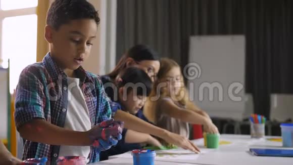 可爱的多样化的孩子在课上用手画画视频的预览图
