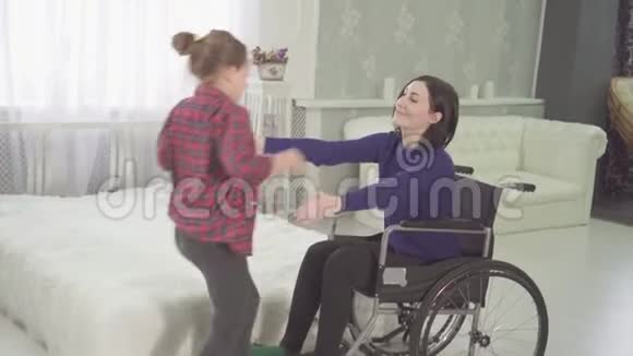 拥抱一位坐轮椅的残疾母亲和她十几岁的女儿视频的预览图