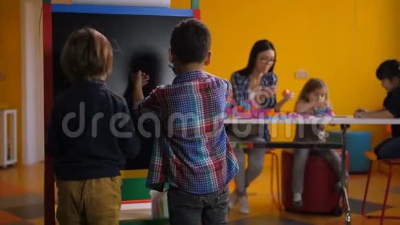 孩子们在幼儿园的黑板上画画视频的预览图