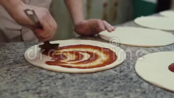 厨师把番茄酱放在披萨面团里视频的预览图