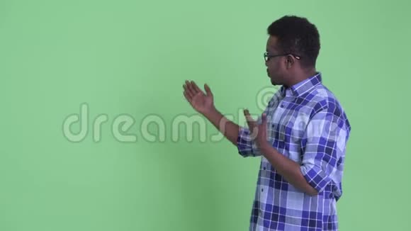 快乐的年轻非洲嬉皮士男子向后面展示了一些东西视频的预览图