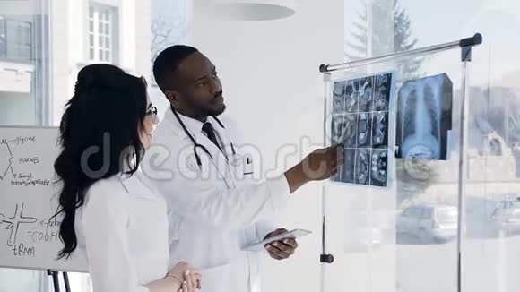 两位年轻的医生在会议室讨论病人的x射线指纹视频的预览图
