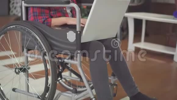 坐在轮椅上坐在笔记本电脑在笔记本电脑旁靠着圣诞树视频的预览图